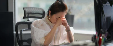 A widowed businesswoman is feeling stressed in an office.