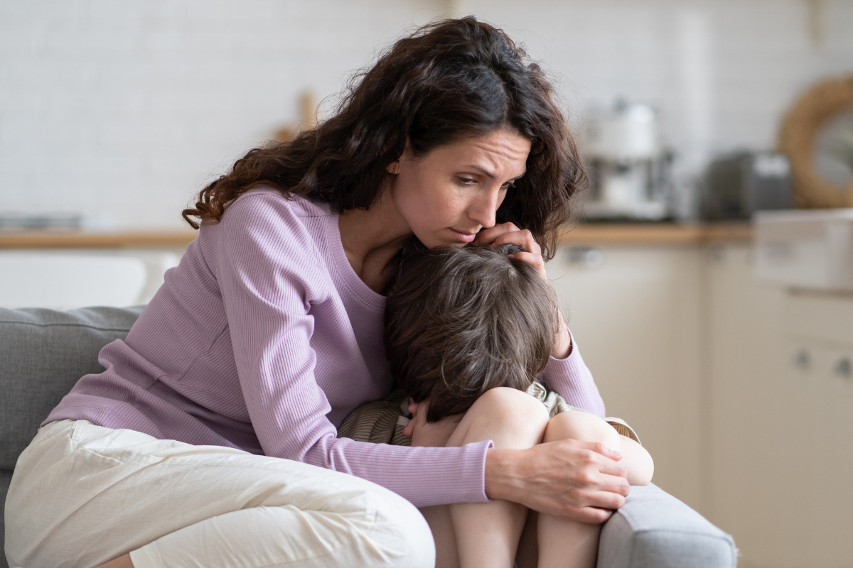 Grieving mom holding sad son